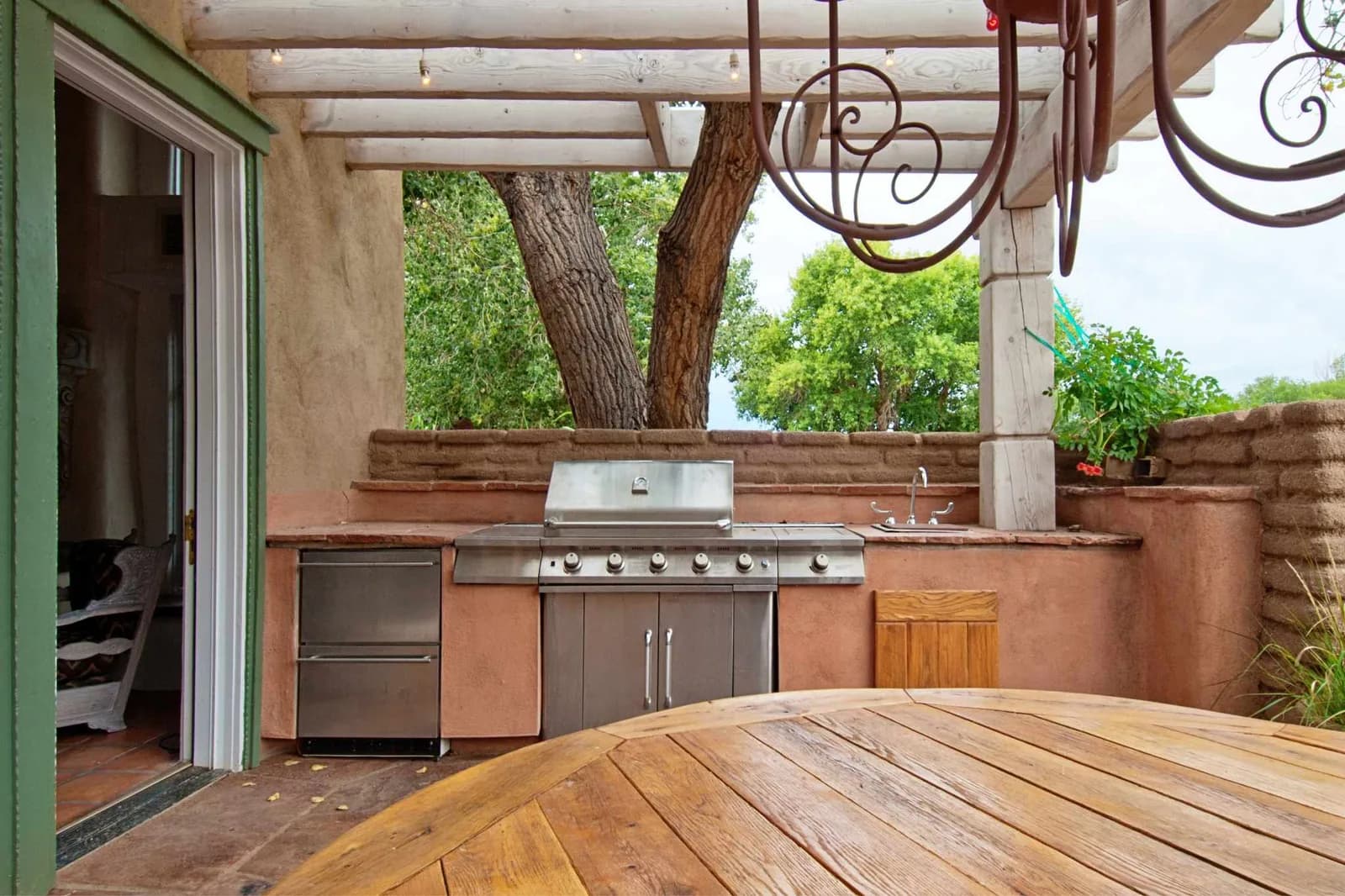 Spanish style outdoor kitchen under pergola