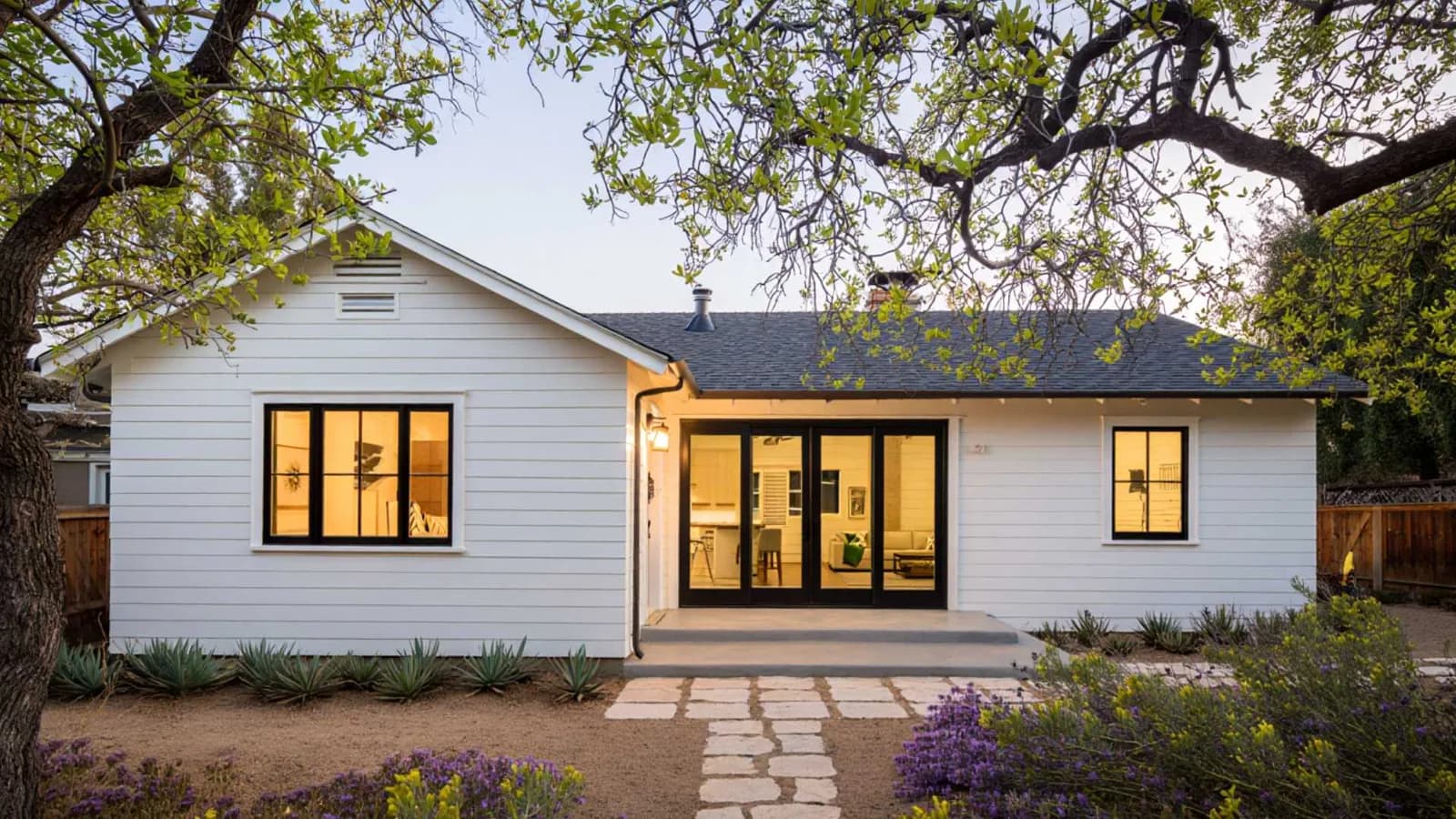 Completed backyard guest house ADU with modern design surrounded by landscaping