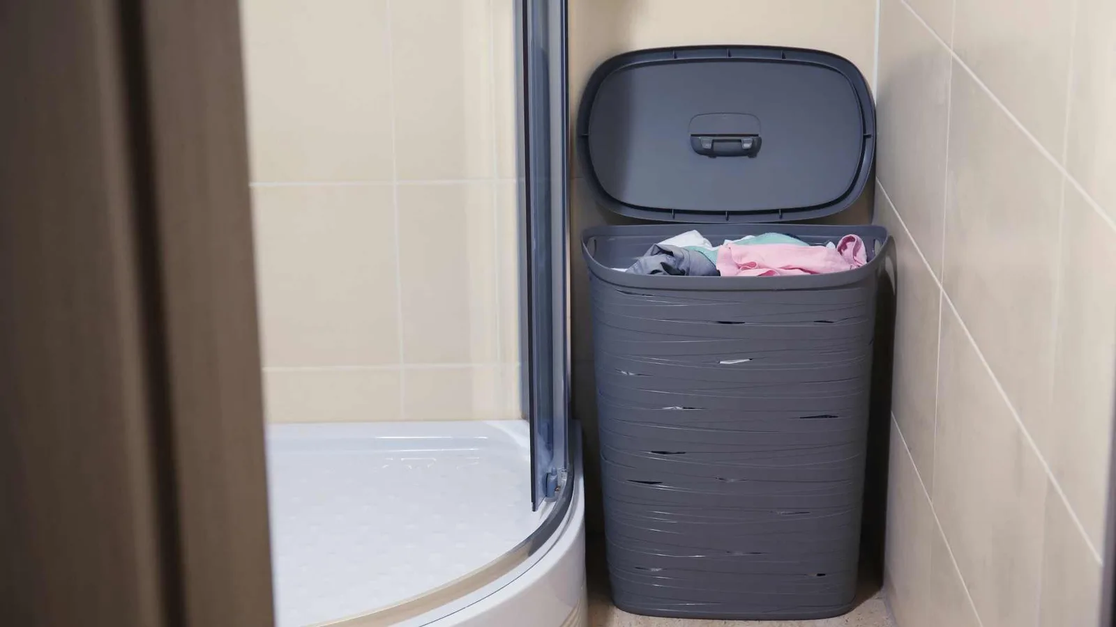 Corner shower with a laundry basket