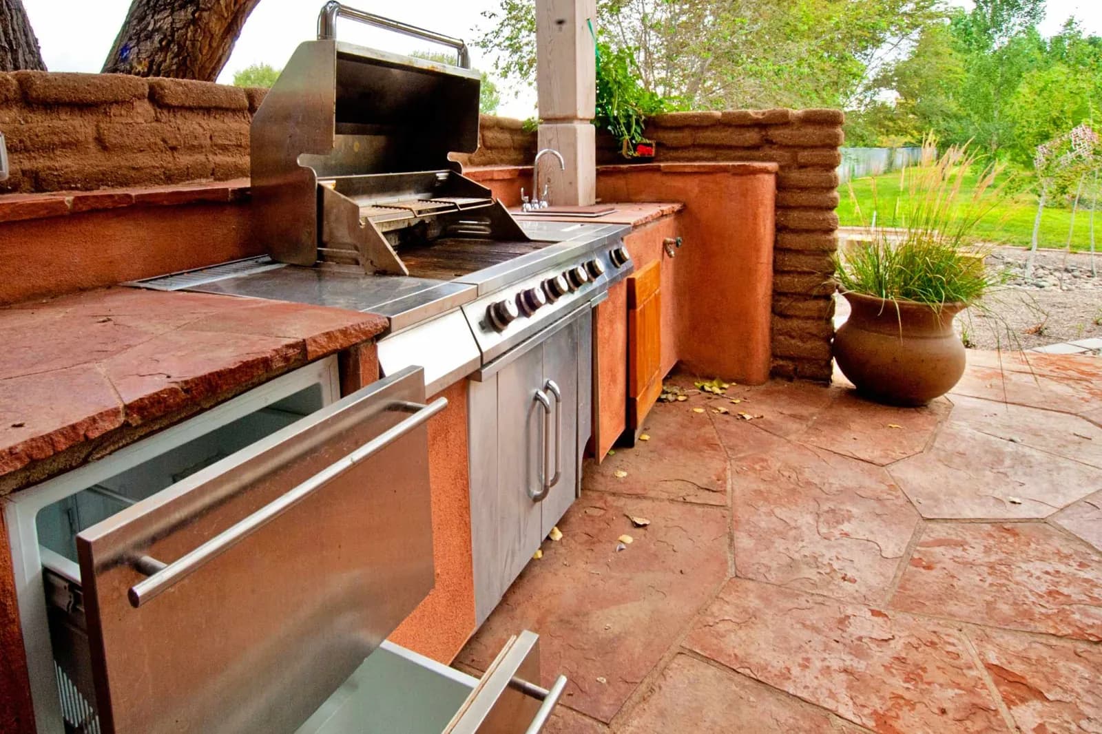 Spanish style outdoor kitchen with fridge, stove and sink