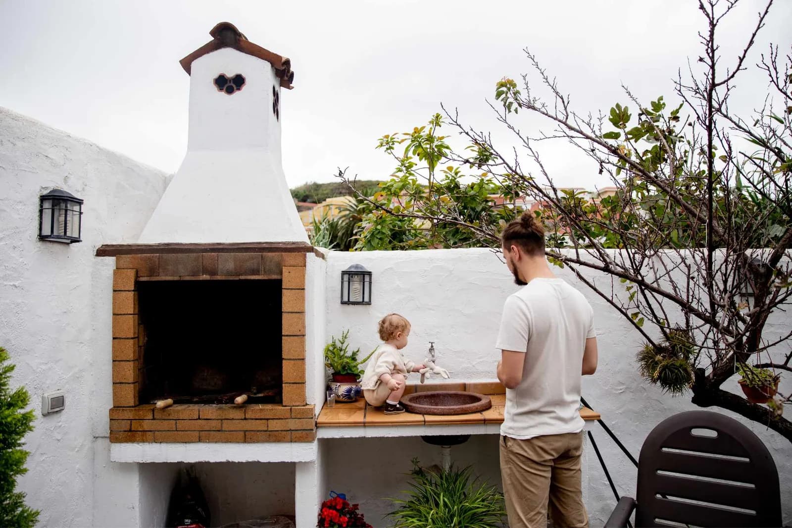 Outdoor kitchen with built-in grill and counter under a covered patio