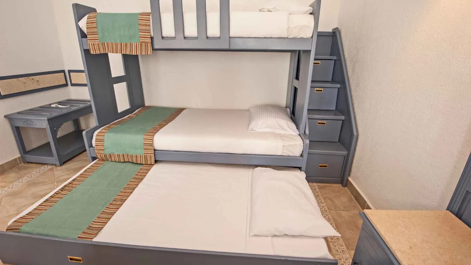 Stacked three-tier bunk beds in a compact bedroom