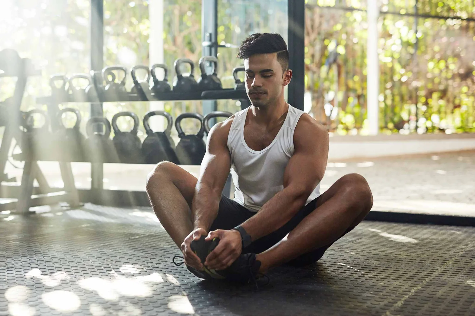 Young man stretching in a workout shed